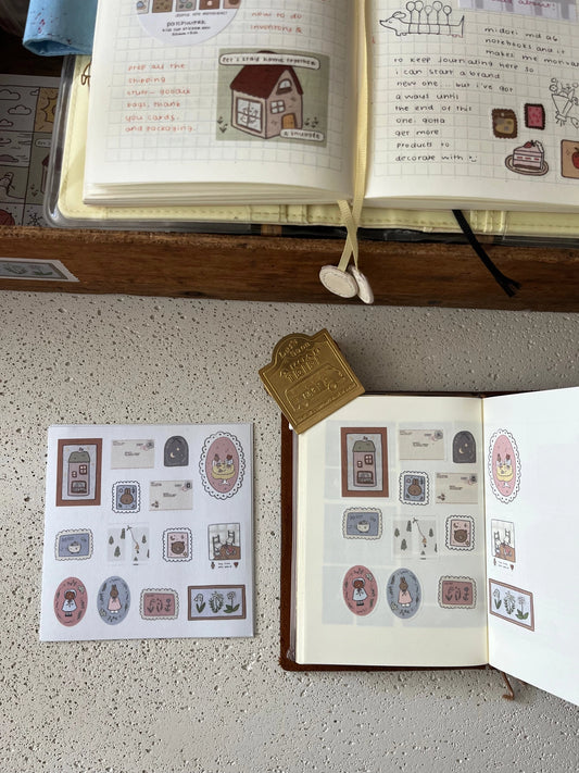 Open book with illustrations and a sheet of kawaii bunny and bear stickers on a textured surface