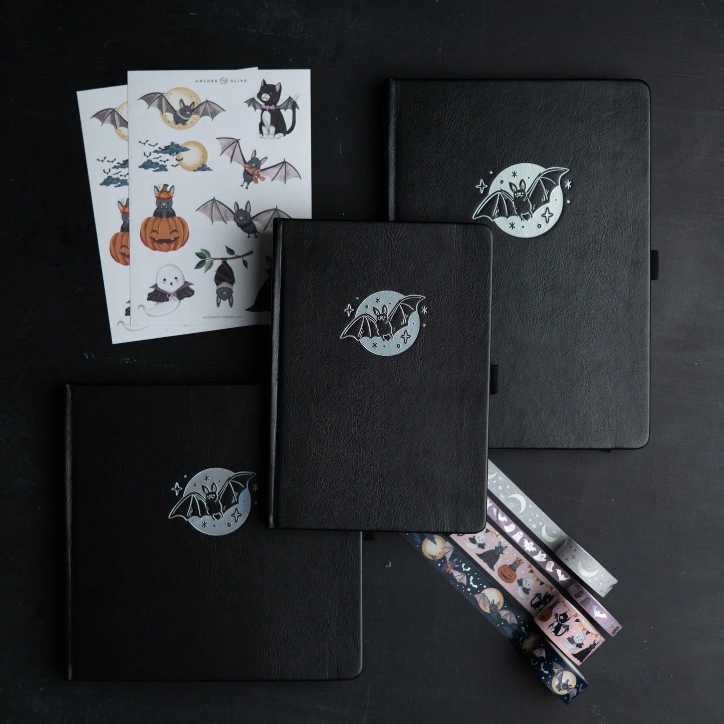 Archer and Olive Cute Bat - Black notebooks and sticker sheets with bat illustrations on a black background