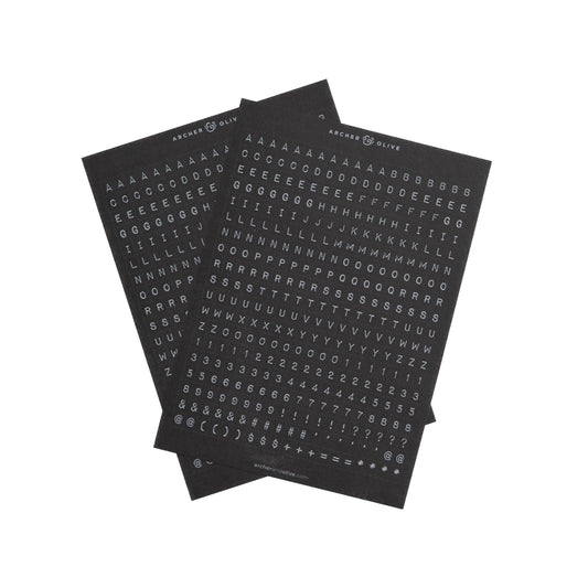 Page of sophisticated alphabet stickers, white letters on a black background. This image shows two sheets of stickers.