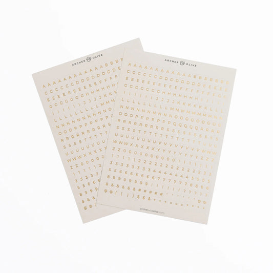 Two sheets of gold letter stickers on a white background