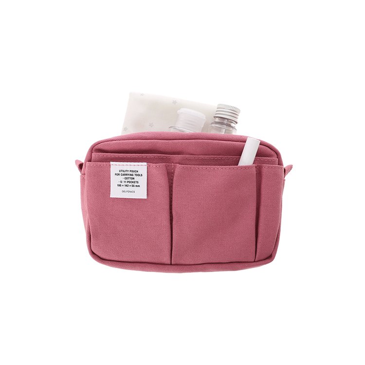 Pink pouch with a white label with the brand Delfonics text on one of the front pockets. The pouch is slightly ajar and contains a bottle and handsanitizer.